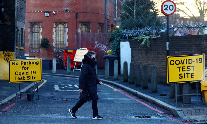 Một người đàn ông đi ngang qua lối vào khu lấy mẫu xét nghiệm Covid-19 tại London, Anh, ngày 21/1. Ảnh: Reuters.