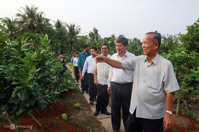 Nguyên Phó thủ tướng Trương Vĩnh Trọng dẫn đoàn khách đến từ TP HCM thăm khu vườn cây ăn trái tại nhà ở Bến Tre, năm 2018. Ảnh: Hữu Khoa
