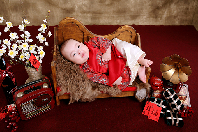 Bé Gia Khang được bố mẹ diện áo dài đỏ. Để buổi chụp diễn ra suôn sẻ, trước đó, hai vợ chồng đã mua sẵn áo dài cho hai con nhỏ, áo dài cho bố mẹ và phụ huynh đôi bên trong 2 tuần.
