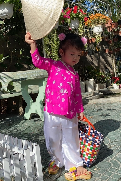 Sáng 30 Tết, con gái được mẹ Lê Phương cho mặc áo bà ba, quần lụa, mang guốc, đội nón, xách giỏ đi chợ Tết.