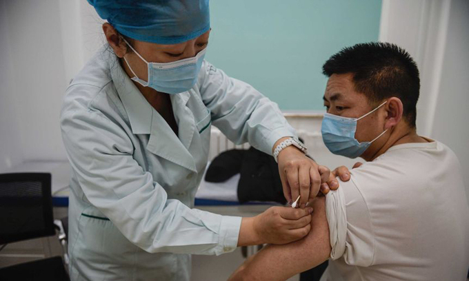 Nhân viên y tế tiêm vaccine Covid-19 cho một người đàn ông ở Bắc Kinh hồi tháng 1. Ảnh: AP.