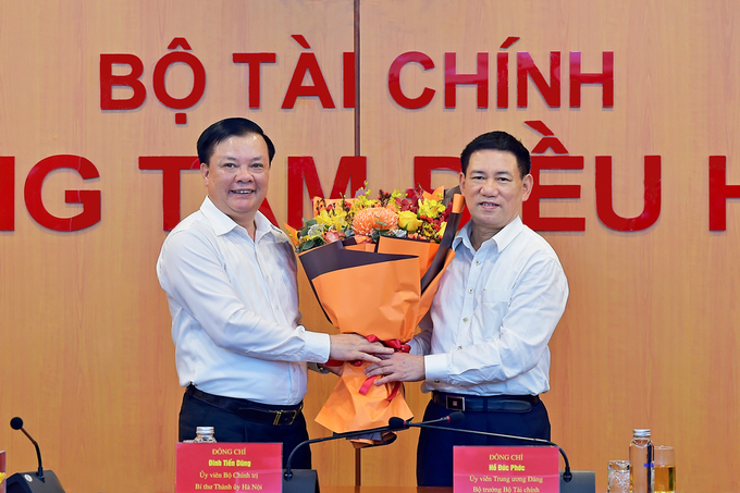 Nguyên Bộ trưởng Tài chính Đinh Tiến Dũng (bên trái) tặng hoa cho Tân Bộ trưởng Hồ Đức Phớc. Ảnh: Bộ Tài chính.