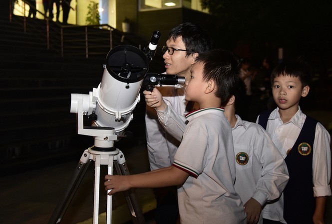 Mạnh Quân hướng dẫn các em nhỏ sử dụng kính thiên văn. Ảnh: Nhân vật cung cấp